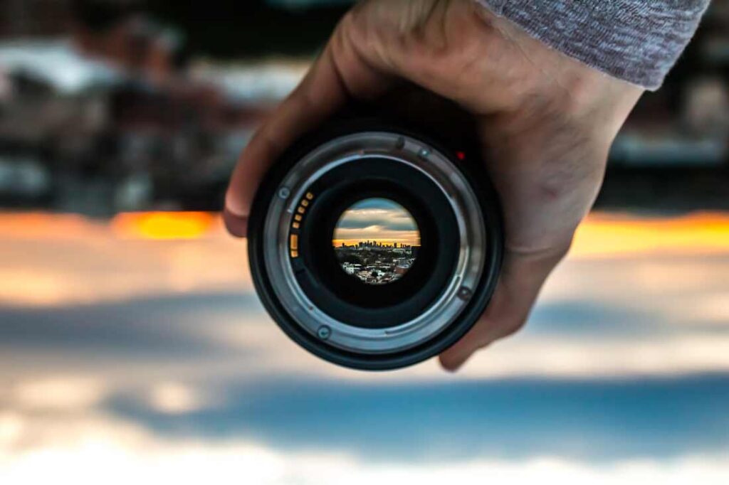 Cut out the noise and focus on the present moment with dharana. Image of lens focussing in on a city far away.