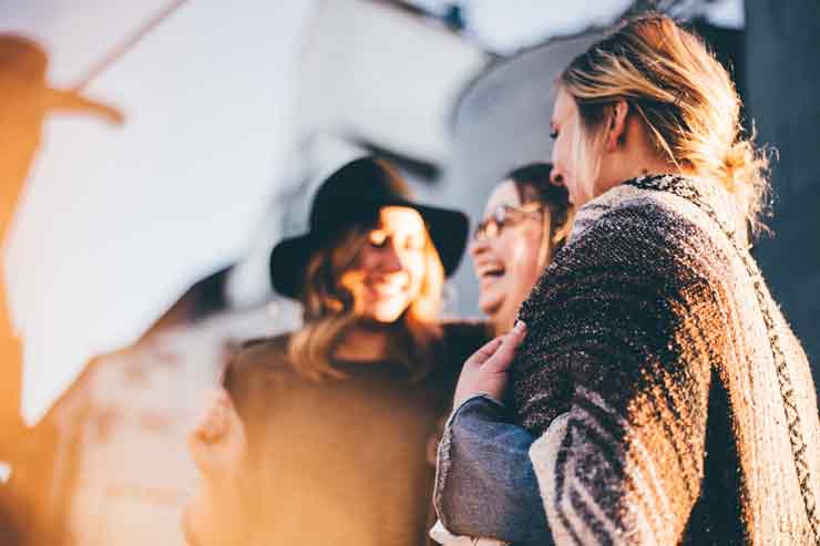 Image of 3 women laughing and moving with the flow of life.